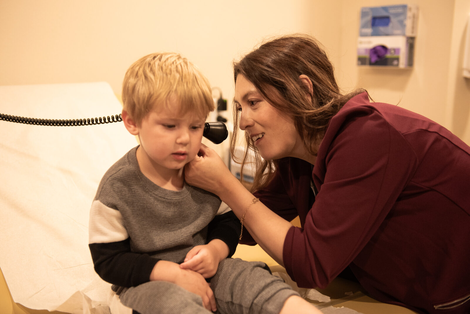 Dr. Katya checking a young child's ear